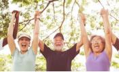 three senior citizens with arms raised over head hold hands in victory 